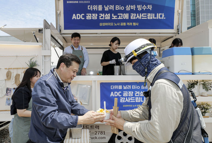 [서울=뉴시스] 삼성바이오로직스 노사는 지난 19일 인천 송도에 위치한 ADC 공장 건설 현장에서 협력사 기술인 900여명을 대상으로 빙수와 츄러스를 제공하는 상생협력 행사를 개최했다. 사진은 이규호 삼성바이오로직스 피플센터 센터장(사진 가운데)이 협력사 기술인에게 빙수를 전달하는 모습 (사진=삼성바이오로직스 제공) 2024.07.22. photo@newsis.com *재판매 및 DB 금지