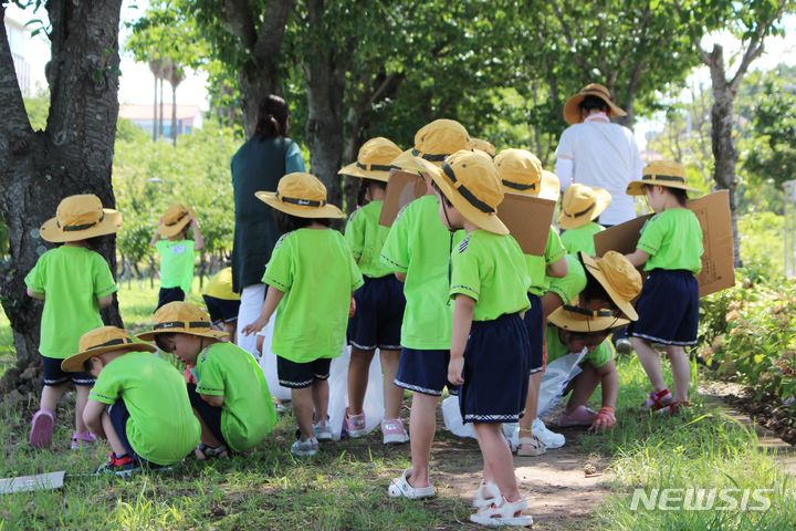 [제주=뉴시스] 양영전 기자 = 제주도가 올해 시범 도입하는 '반려 가로수 입양' 사업에 참여하는 '인예어린이집' 원아들이 22일 오전 관리 구간인 제주시 도남동 시민복지타운광장 일대 가로수 주변 환경 정화를 하고 있다. 2024.07.22. 0jeoni@newsis.com 