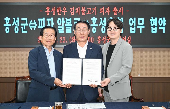 [홍성=뉴시스] 이용록(가운데) 홍성군수와 이대영(왼쪽) 홍성축협조합장, 이재욱 피자알볼로 대표가 23일 군청 회의실에서 ‘홍성한우 김치불고기피자’ 출시를 위한 협약식을 갖고 있다. *재판매 및 DB 금지