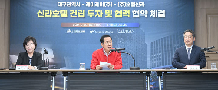 [대구=뉴시스]홍준표 대구시장이 23일 오전 시청 산격청사에서 박윤경 케이케이 대표이사, 이정호 호텔신라 부사장과 함께 ‘프리미엄급 호텔건립 투자·협력협약(MOU)’을 체결하고 있다(사진=대구시 제공) 2024.07.23 photo@newsis.com *재판매 및 DB 금지