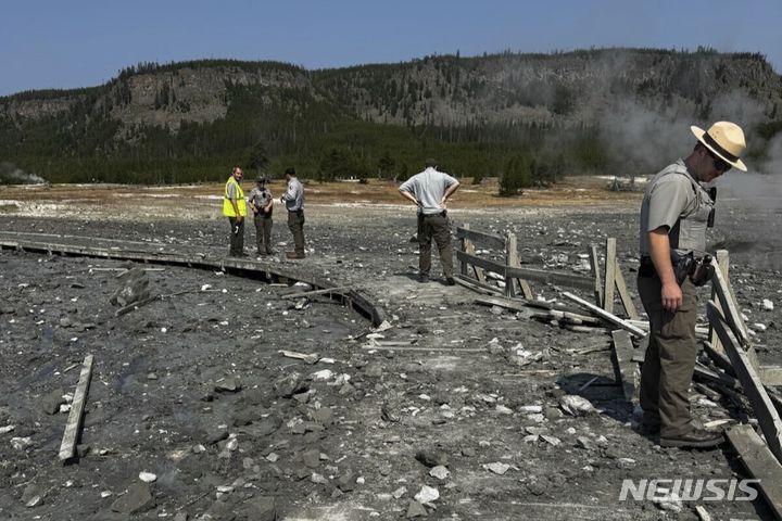 [옐로스톤 국립공원( 미 와이오밍주)=AP/뉴시스] 미 옐로스톤 국립공원에서 23일( 현지시간) 온천수 대폭발이 일어난 뒤 부서진 관광객 탐방로 난간들과 폐허를 조사하는 국립공원 직원들. 2024. 07.24. 
