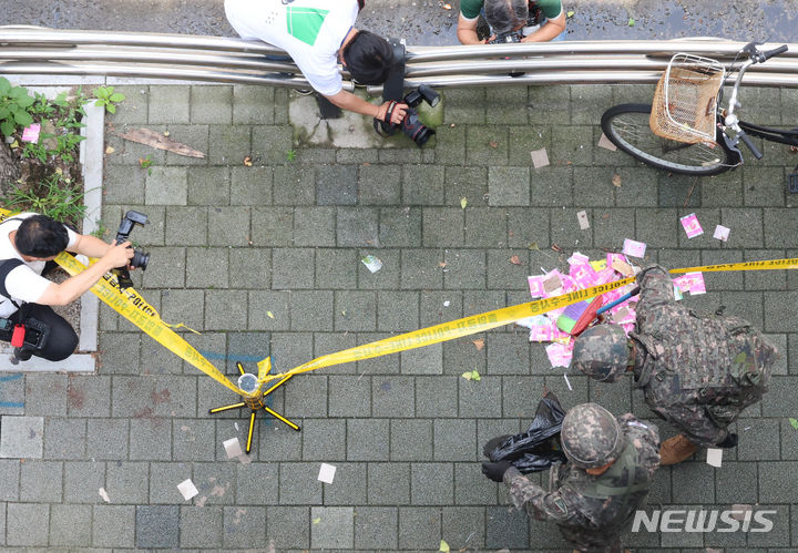 [인천=뉴시스] 전진환 기자 = 북한이 재차 오물풍선을 날려 보낸 24일 오후 인천 부평구 부평고등학교 인근 인도에서 군 장병들이 풍선에서 떨어진 것으로 추정되는 인쇄물이 봉투에 담고 있다.&nbsp; 2024.07.24. amin2@newsis.com