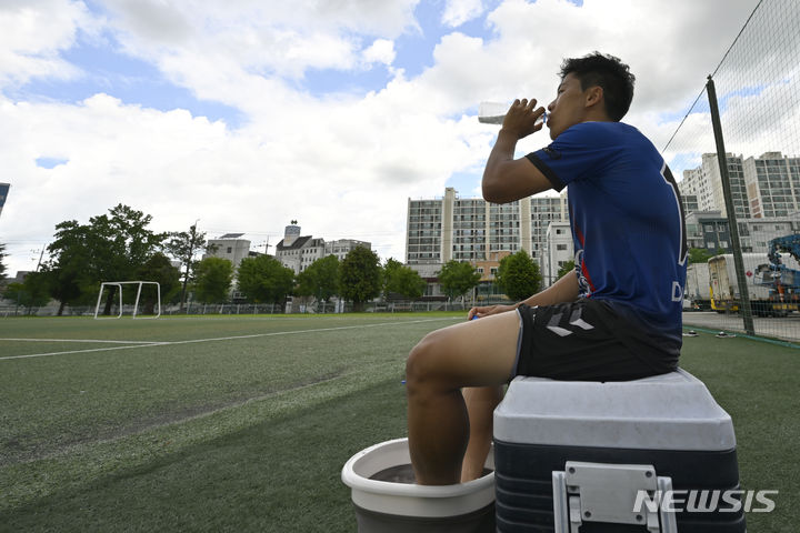 [광주=뉴시스] 박기웅 기자 = 광주에 사흘째 폭염경보가 발효되는 등 무더운 날씨를 보인 24일 동강대학교 운동장에서 축구부 한 선수가 개인 훈련을 마친 뒤 얼음물을 마시며 휴식을 취하고 있다. 2024.07.24. pboxer@newsis.com