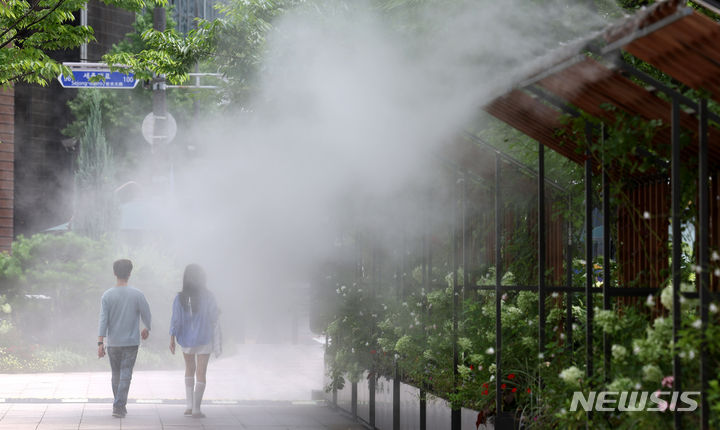 [서울=뉴시스] 추상철 기자 = 장마가 소강상태에 접어 들면서 무더운 날씨를 보인 24일 오후 서울 중구 서울시청 앞에서 행인들이 더위를 피해 쿨링포그 아래로 지나가고 있다. 2024.07.24. scchoo@newsis.com