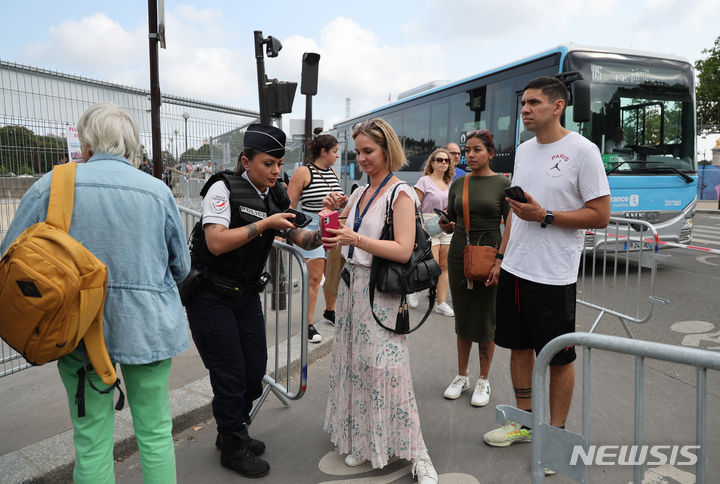 [파리=뉴시스] 김진아 기자 = 2024 파리 올림픽 개막을 이틀 앞둔 24일(현지시각) 프랑스 파리 레쟁발리드 다리 인근에서 경찰이 QR코드 형태의 통행증을 확인하고 있다. 2024.07.24. bluesoda@newsis.com