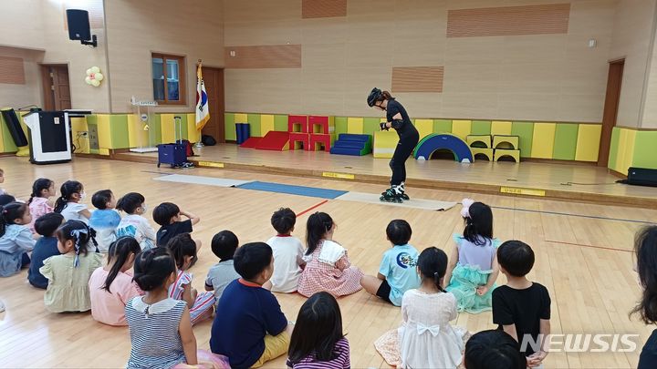 [화성=뉴시스] 1일 교사로 나선 학부모가 아이들에게 인라인스케이트를 탈 때 올바른 보호장구 착용 방법을 알려주고 있다.(사진=오산화성교육지원청)2024.07.25.photo@newsis.com