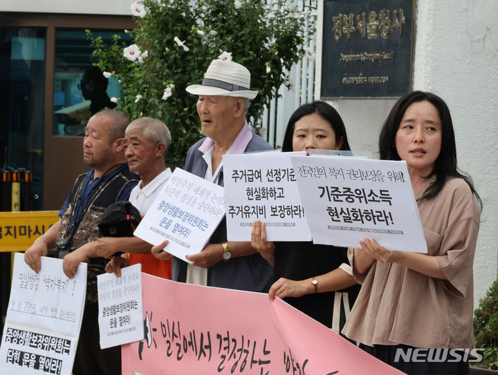 [서울=뉴시스] 김명원 기자 = 기초법바로세우기 공동행동 등 참석자들이 지난해 7월 25일 오전 서울 종로구 정부서울청사 앞에서 정부 중앙생활보장위원회에 기준중위소득 현실화와 부양의무자기준 완전 폐지를 요구하는 민중생활보장위원회 기자회견을 하고 있다. 2024.07.25. kmx1105@newsis.com