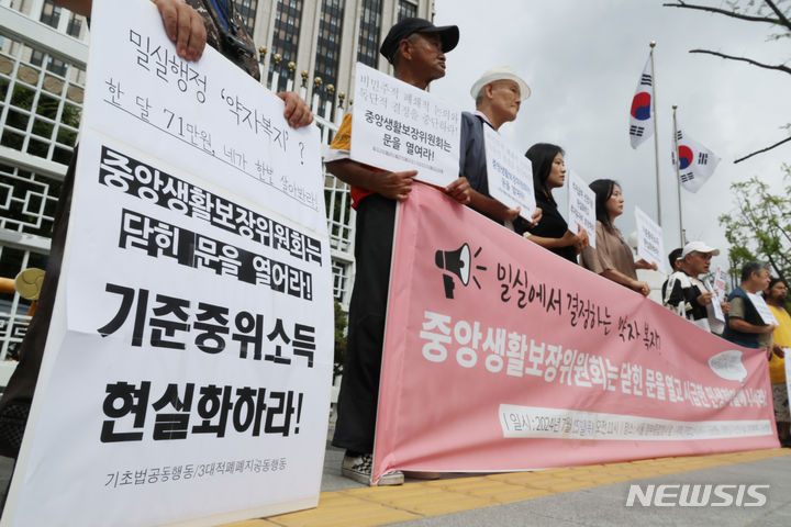 [서울=뉴시스] 기초법바로세우기 공동행동 등 참석자들이&nbsp; 지난해 7월 25일 오전 서울 종로구 정부서울청사 앞에서 정부 중앙생활보장위원회에 기준중위소득 현실화와 부양의무자기준 완전 폐지를 요구하는 민중생활보장위원회 기자회견을 하는 모습. (사진=뉴시스 DB) 2024.07.25. photo@newsis.com