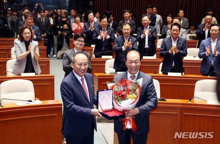 [서울=뉴시스] 조성봉 기자 = 황우여 (오른쪽) 국민의힘 비대위원장이 25일 오전 서울 여의도 국회에서 열린 의원총회에서 추경호 원내대표에게 감사패를 받고 기념촬영을 하고 있다. 2024.07.25. suncho21@newsis.com