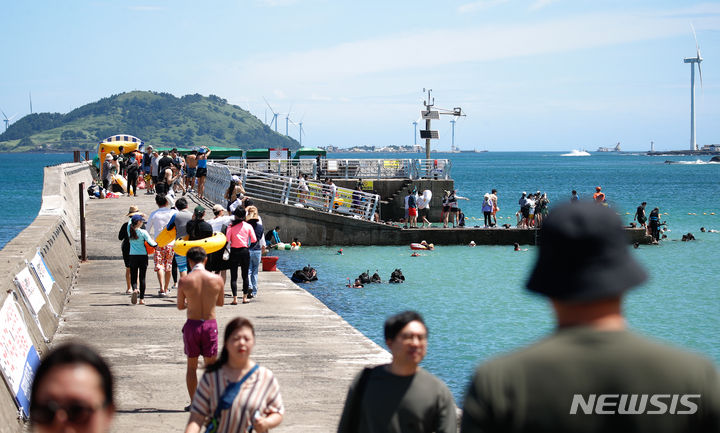 [제주=뉴시스] 우장호 기자 = 장마 전선이 소강상태이 놓이며 무더운 날씨가 이어진 25일 오전 제주시 한경면 판포포구에 피서객이 찾아와 시원한 물놀이로 한낮 더위를 식히고 있다. 2024.07.25. woo1223@newsis.com