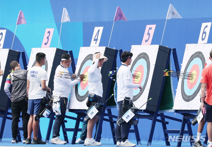 [파리=뉴시스] 김진아 기자 = 2024 파리올림픽 대한민국 양궁대표팀 김우진,, 김제덕, 이우석이 25일(현지시간) 프랑스 파리 에펠탑 레쟁발리드에서 열린 남자 개인전 랭킹라운드에서 과녁을 확인하고 있다. 2024.07.26. bluesoda@newsis.com