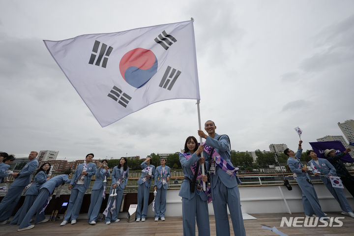 [파리=AP/뉴시스] 2024 파리 올림픽 개회식이 열린 26일(현지시각) 프랑스 파리 센강에서 보트를 탄 대한민국 수영 김서영, 육상 우상혁이 태극기를 흔들고 있다. 2024.07.27.