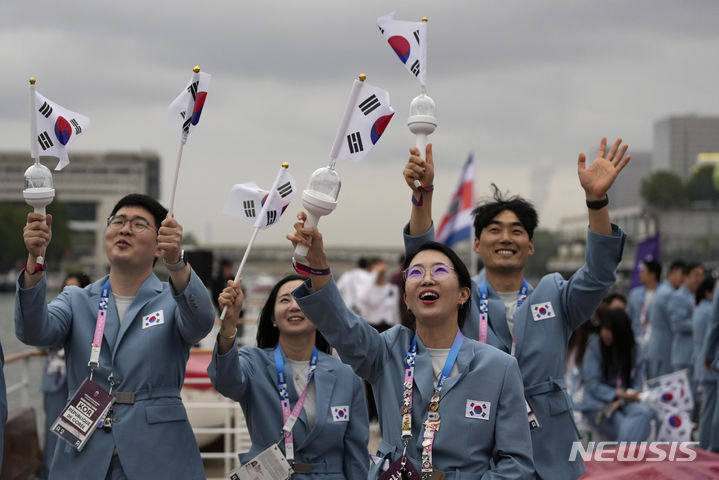 [파리=AP/뉴시스] 2024 파리 올림픽 개회식이 열린 26일(현지시각) 프랑스 파리 센강에서 보트를 탄 대한민국 선수들이 손을 흔들고 있다. 2024.07.27.