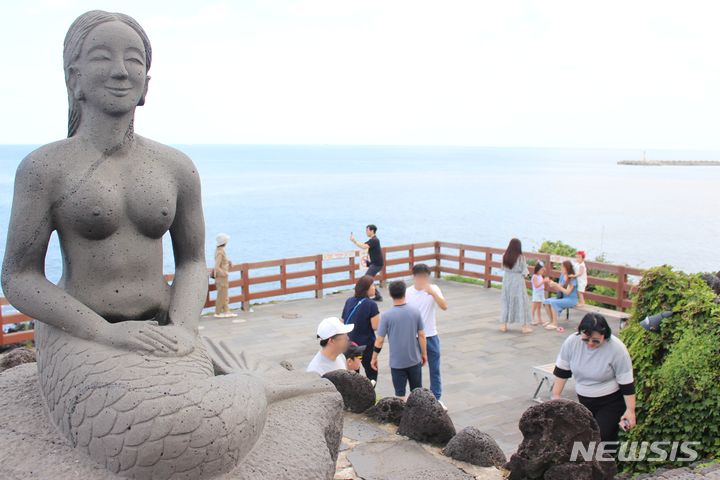 [제주=뉴시스] 양영전 기자 = 장맛비가 소강상태에 든 27일 오후 제주시 용담2동 용두암을 찾은 관광객들이 즐거운 시간을 보내고 있다. 2024.07.27. 0jeoni@newsis.com 