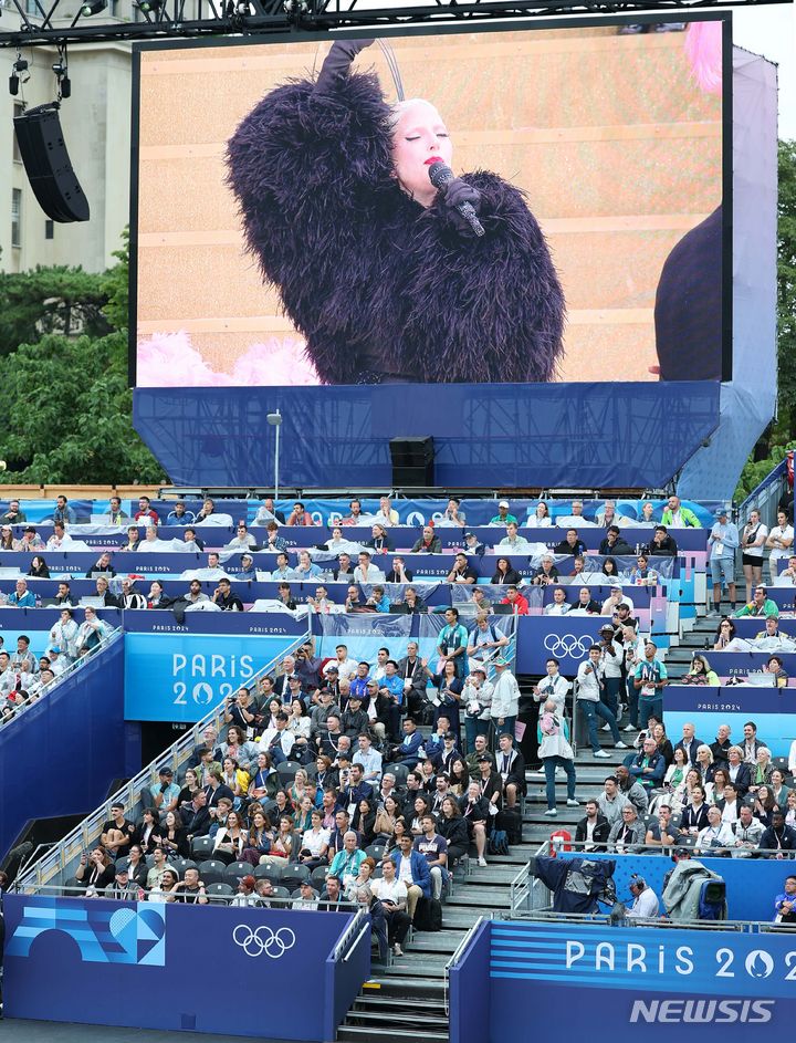 [파리=뉴시스] 김진아 기자 = 2024 파리올림픽 개회식이 열린 26일(현지시각) 프랑스 파리 트로카데로광장에 설치된 개회식장에서 관객들이 레이디 가가의 축하공연을 보고 있다. (공동취재) 2024.07.27. photo@newsis.com