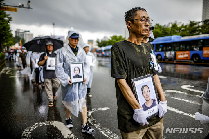 [서울=뉴시스] 정병혁 기자 = 27일 서울 용산구 대통령실 앞에서 열린 아리셀 중대재해 참사 희생자 가족 영정 행진에서 희생자 유가족과 참석자들이 영정을 든 채 서울역 방향으로 행진하고 있다. 2024.07.27. jhope@newsis.com