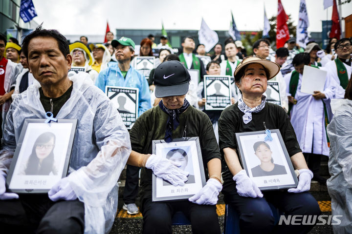 [서울=뉴시스] 정병혁 기자 = 27일 서울 중구 서울역 광장에서 열린 아리셀 중대재해 참사 희생자 시민추모제에서 유가족 및 참석자들이 희생자 영정을 들고 있다. 2024.07.27. jhope@newsis.com