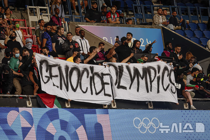 [파리=AP/뉴시스] 가자지구 전쟁과 중동 지역 갈등으로 이스라엘의 전운이 확대되는 가운데, 2024 파리올림픽에 참가한 이스라엘 선수들이 각종 증오 범죄에 노출되고 있다. 사진은 지난달 28일 프랑스 파리 파르크 데 프랭스에서 열린 올림픽 남자 축구 D조 2차전 이스라엘과 파라과이의 경기 중 일부 관중이 '집단학살 올림픽'(Genocide Olympics)이라 적힌 현수막을 들고 있는 모습. 2024.07.31.