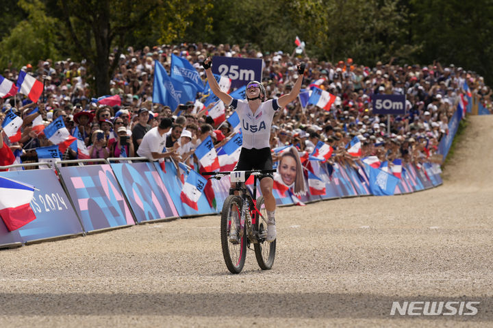 [파리=AP/뉴시스] 미국 산악자전거 여자 국가대표 헤일리 배튼(25)이 바퀴 파손 등의 역경에도 미국 역사상 최고 성적으로 은메달을 거머쥐었다. 사진은 배튼이 28일(현지시각) 프랑스 파리 엘랑쿠르에서 열린 여자 산악자전거에서 1시간28분59초의 기록으로 결승선을 통과하는 모습. 2024.07.28.