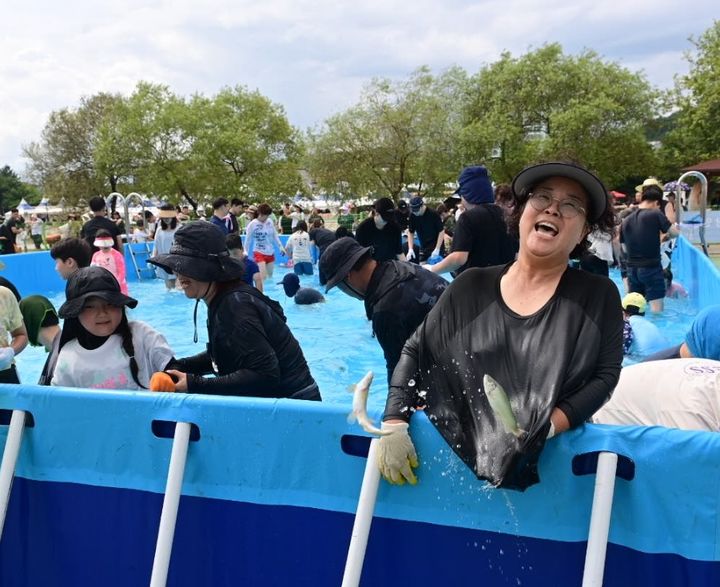 [봉화=뉴시스] 봉화은어축제 방문객들이 '은어 맨손잡이'에 참가해 은어를 잡고 있다. (사진=봉화군 제공) 2024.07.28. photo@newsis.com  *재판매 및 DB 금지