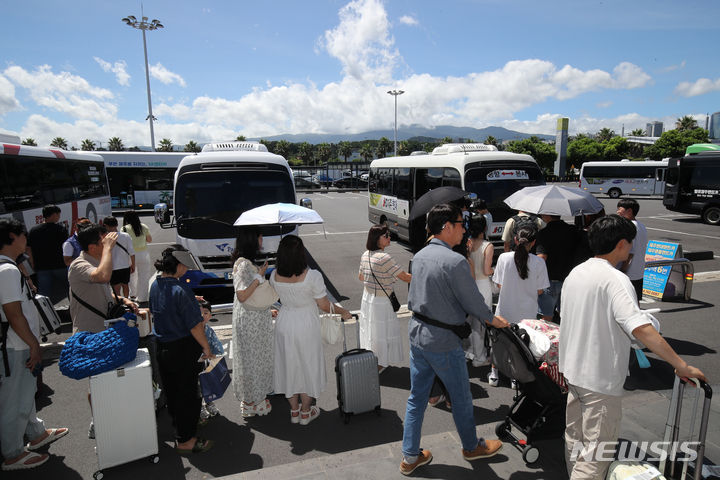 [제주=뉴시스] 우장호 기자 = 본격적인 여름 휴가철이 시작된 28일 오전 제주국제공항 내 렌터카하우스에서 관광객들이 공항과 렌터카 회사를 오가는 셔틀버스에 탑승하고 있다. 2024.07.28. woo1223@newsis.com