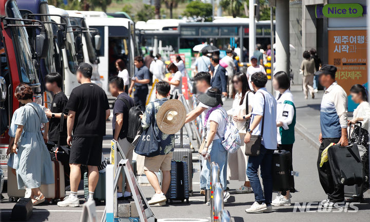 [제주=뉴시스] 우장호 기자 = 본격적인 여름 휴가철이 시작된 28일 오전 제주국제공항 내 렌터카하우스에서 관광객들이 공항과 렌터카 회사를 오가는 셔틀버스에 탑승하고 있다. 2024.07.28. woo1223@newsis.com