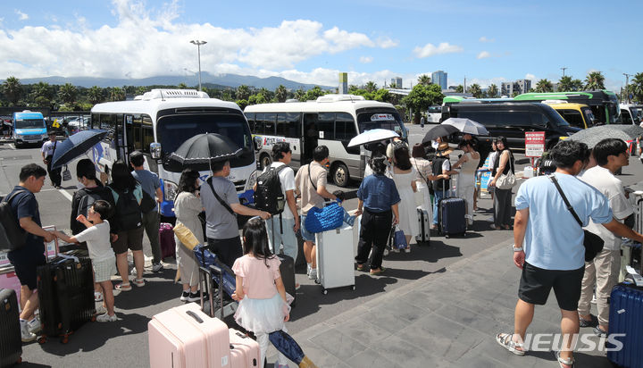 [제주=뉴시스] 우장호 기자 = 본격적인 여름 휴가철이 시작된 28일 오전 제주국제공항 내 렌터카하우스에서 관광객들이 공항과 렌터카 회사를 오가는 셔틀버스에 탑승하고 있다. 2024.07.28. woo1223@newsis.com