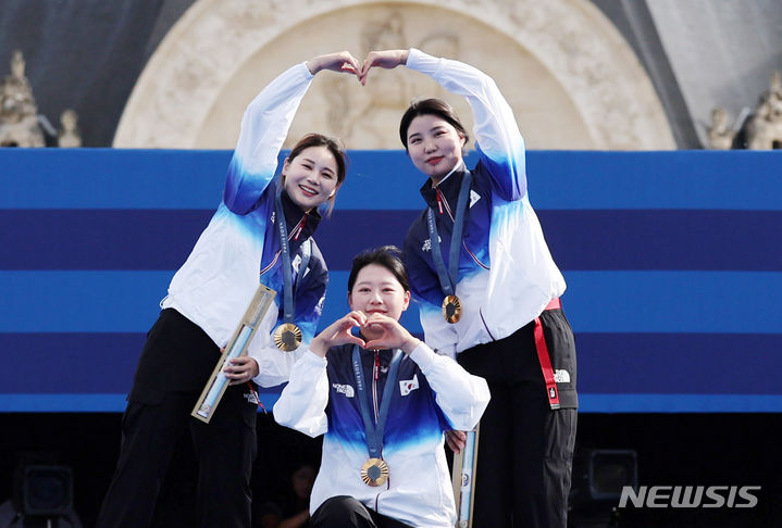 [파리=뉴시스] 김진아 기자 = 임시현, 전훈영, 남수현이 28일(현지시간) 프랑스 파리 레쟁발리드에서 열린 파리 올림픽 양궁 여자 단체전 시상식에서 금메달을 목에 걸고 세리머니를 하고 있다.  2024.07.29. bluesoda@newsis.com