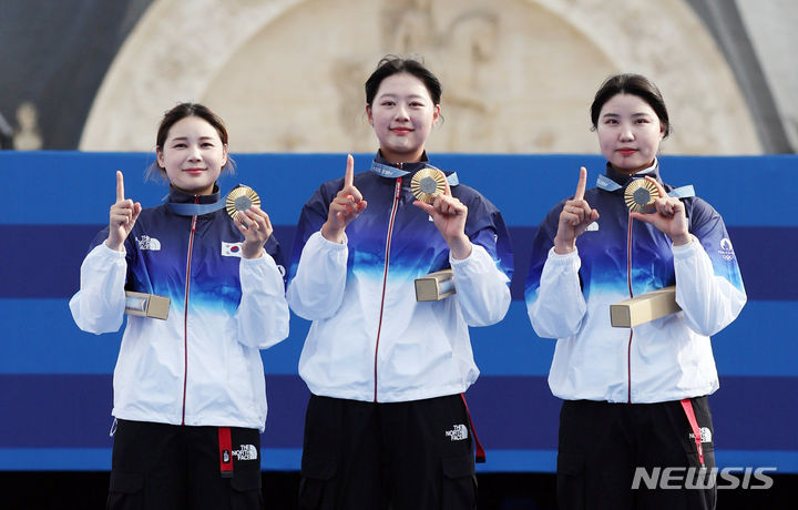 [파리=뉴시스] 김진아 기자 = 임시현, 전훈영, 남수현이 지난 28일(현지시간) 프랑스 파리 레쟁발리드에서 열린 파리 올림픽 양궁 여자 단체전 시상식에서 금메달을 목에 걸고 세리머니를 하고 있다.  2024.07.29. bluesoda@newsis.com