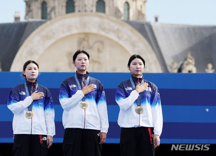 [파리=뉴시스] 김진아 기자 = 임시현, 전훈영, 남수현이 28일(현지시간) 프랑스 파리 레쟁발리드에서 열린 파리 올림픽 양궁 여자 단체전 시상식에서 금메달을 목에 걸고 국기에 대한 경례를 하고 있다. 2024.07.29. bluesoda@newsis.com