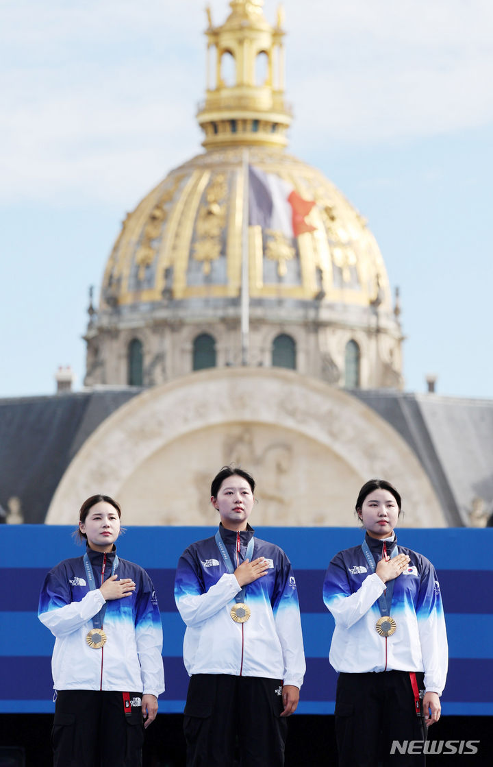 [파리=뉴시스] 김진아 기자 = 임시현, 전훈영, 남수현이 28일(현지시간) 프랑스 파리 레쟁발리드에서 열린 파리 올림픽 양궁 여자 단체전 시상식에서 금메달을 목에 걸고 국기에 대한 경례를 하고 있다. 2024.07.29. bluesoda@newsis.com