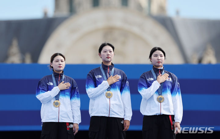 [파리=뉴시스] 김진아 기자 = 임시현, 전훈영, 남수현이 28일(현지시간) 프랑스 파리 레쟁발리드에서 열린 파리 올림픽 양궁 여자 단체전 시상식에서 금메달을 목에 걸고 국기에 대한 경례를 하고 있다. 2024.07.29. bluesoda@newsis.com