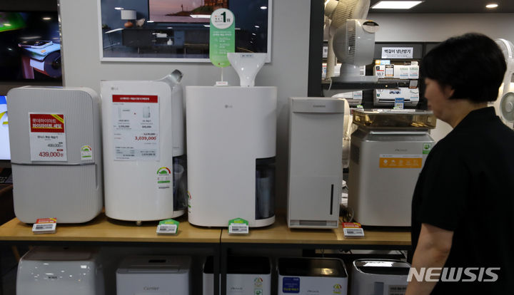 [서울=뉴시스] 김혜진 기자 = 서울 지역의 7월 평균 습도가 3년 연속 증가 추세인 것으로 나타났다. 지난 23일 기상청 통계를 살펴보면 서울 지역의 7월 평균습도는 2021년 70.9%에서 지난해 81.1%로 2년 새 10.2%p 올랐다. 올해 역시(21일 기준) 평균 81%의 습도를 기록하며 지난해와 비슷한 수준을 유지하고 있다. 사진은 29일 서울 시내 한 대형마트를 찾은 시민들이 제습기 등을 둘러보고 있다. 2024.07.29. jini@newsis.com