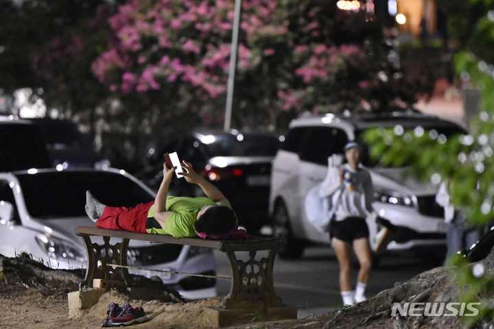 [광주=뉴시스] 박기웅 기자 = 열대야를 피해 광주 북구 용봉동 전남대학교를 찾은 한 시민이 벤치에 누워 더위를 식히고 있다. (뉴시스 DB) pboxer@newsis.com