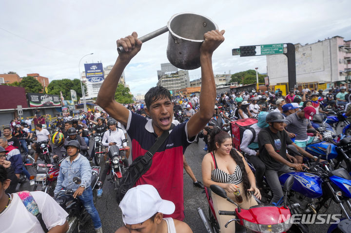 [카라카스=AP/뉴시스] 29일(현지시각) 베네수엘라 카라카스에서 니콜라스 마두로 대통령의 3선 선거 결과에 반대하는 시위 참가자가 냄비를 두드리며 '카세롤라소' 시위를 하고 있다. 베네수엘라 대선을 둘러싼 부정·불공정 정황이 쏟아지면서 이에 항의하는 유권자들의 시위가 거세지고 있다. 2024.07.30.