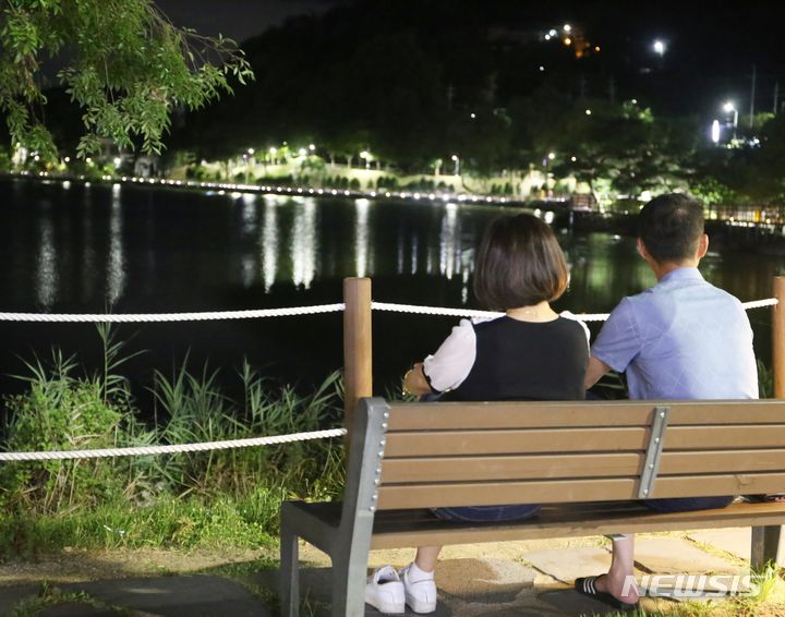 [청주=뉴시스] 서주영 기자 = 29일 오후 청주시 명암저수지 산책로 벤치에서 시민들이 야경을 감상하고 있다. 2024.07.29. juyeong@newsis.com *재판매 및 DB 금지