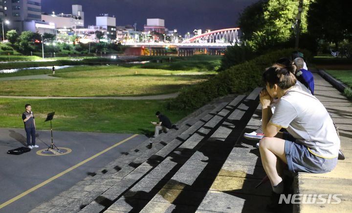 [청주=뉴시스] 서주영 기자 = 29일 오후 청주 무심천체육공원에서 시민들이 버스킹 공연을 관람하고 있다. 2024.07.29. juyeong@newsis.com *재판매 및 DB 금지