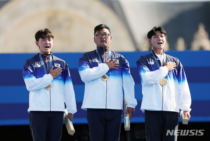 [파리=뉴시스] 김진아 기자 = 김우진, 김제덕, 이우석이 지난달 29일(현지시각) 프랑스 파리 레쟁발리드에서 열린 파리올림픽 양궁 남자 단체전 시상식에서 금메달을 목에 걸고 국기에 대한 경례를 하고 있다. 2024.07.30. bluesoda@newsis.com