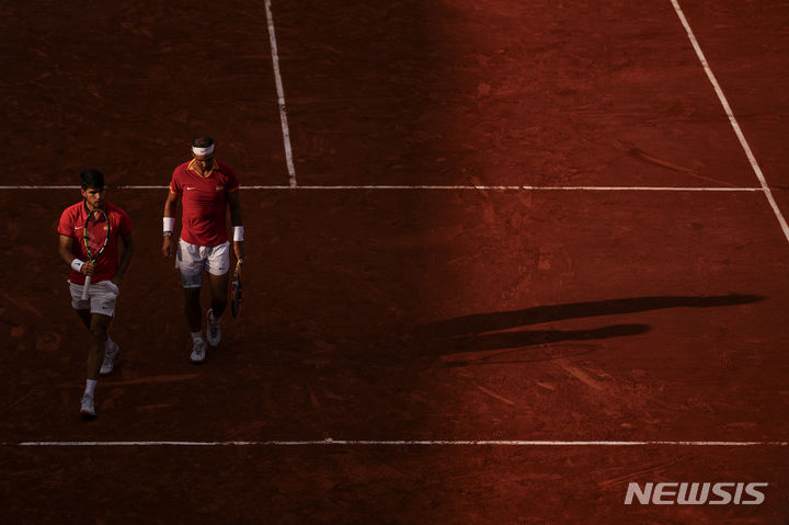 [파리=AP/뉴시스] 스페인 테니스 국가대표 라파엘 나달(왼쪽)과 카를로스 알카라스가 31일(한국시각) 프랑스 파리의 롤랑가로스 경기장에서 열린 '2024 파리올림픽' 테니스 남자 복식 2차전에서 네덜란드의 탈론 그리에크스푸르-베슬리 쿨호프 조와 경기를 펼치고 있다. 2024.07.31.