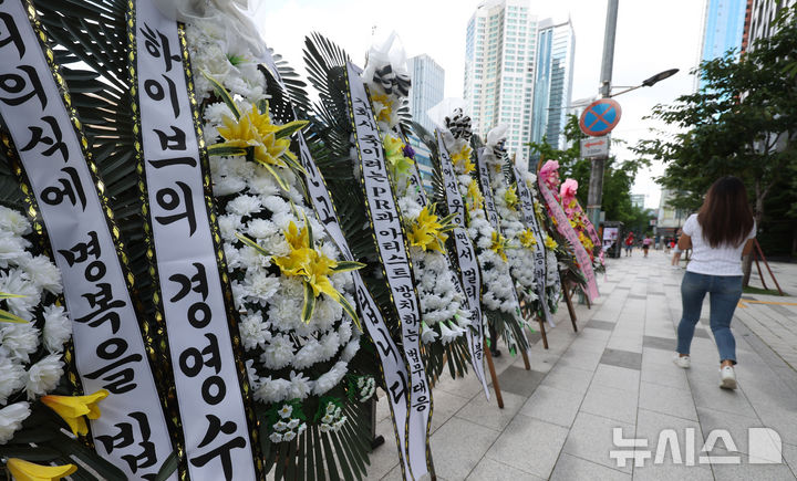 [서울=뉴시스] 추상철 기자 = 31일 오후 서울 용산구 하이브 사옥 앞에 그룹 뉴진스의 팬들이 보낸 근조화환이 놓여 있다. 뉴진스 팬들은 하이브 사옥 앞에서 뉴진스 소속사 어도어 및 민희진 대표를 지지하는 트럭 시위를 벌여 왔으며 이날 근조화환 설치를 하는 등 시위를 이어갔다. 2024.07.31. scchoo@newsis.com