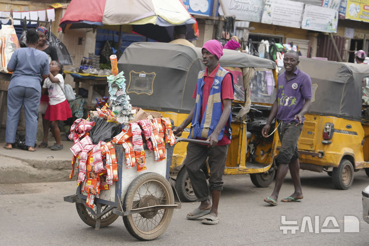 [라고스=AP/뉴시스] 7월31일 나이지리아 라고스 거리에서 한 노점상이 봉지 음료를 팔고 있다. 날로 심해지는 경제난에 분노한 나이지리아 젊은이들은 8월 1일부터 전국적인 시위를 시작했고&nbsp; 정부는 강경 대응으로 일관하고 있다. 2024.08.02.