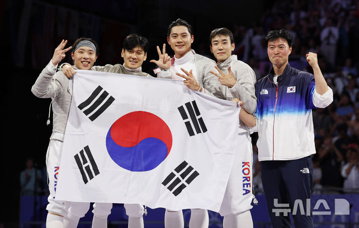 [파리=뉴시스] 최동준 기자 = 구본길, 오상욱, 박상원, 도경동, 원우영 코치가 31일(현지시각) 프랑스 파리 그랑 팔레에서 열린 2024 파리 올림픽 펜싱 남자 사브르 단체 결승 헝가리와의 경기에서 승리하며 금메달을 확정한 뒤 '3연패'를 의미하는 포즈를 취하고 있다. 2024.08.01. photocdj@newsis.com