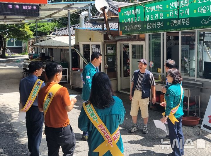 [함양=뉴시스]경남도 민기식(뒷줄 가운데) 환경산림국장이 지난 2일 함양군 농월정 일원에서 바가지요금 근절 및 물가점검 활동을 하고 있다.(사진=경남도 제공)2024.08.03. photo@newsis.com