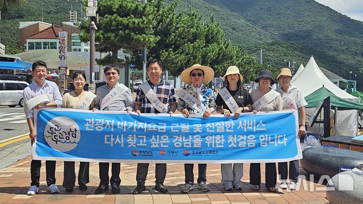 [거제=뉴시스]지난 2일 오전 거제 학동흑진주몽돌해수욕장에서 열린 경남도, 거제시, 경남관광협회 민관합동 '관광지 바가지요금 근절 및 친절 캠페인' 참여자들이 기념촬영하고 있다.(사진=경남도 제공)2024.08.03. photo@newsis.com