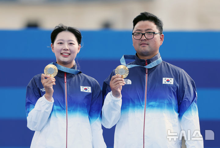 [파리=뉴시스] 김진아 기자 = 김우진과 임시현이 2일(현지시각) 프랑스 파리 레쟁발리드에서 열린 2024 파리 올림픽 양궁 혼성 단체 시상식에서 금메달을 목에 걸고 기뻐하고 있다. 2024.08.03. bluesoda@newsis.com