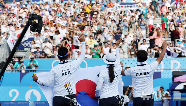 [파리=뉴시스] 김진아 기자 = 김우진-임시현이 2일(현지시각) 프랑스 파리 레쟁발리드에서 열린 2024 파리 올림픽 양궁 혼성 단체 결승 독일과의 경기에서 승리하며 금메달을 확정한 뒤 관중들을 향해 인사하고 있다. 2024.08.03. bluesoda@newsis.com