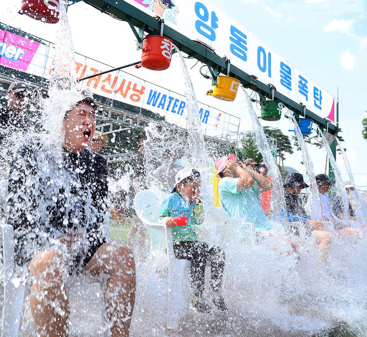 [서울=뉴시스] 추상철 기자 = 4일 오후 강원도 평창군 대화면 땀띠공원 일원에서 열린 ‘2024년 평창더위사냥축제’에서 방문객이 양동이 물폭탄을 맞으며 더위를 식히고 있다. (사진= 평창군 제공) 2024.08.04. photo@newsis.com *재판매 및 DB 금지