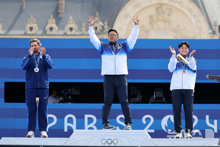 [파리=뉴시스] 김진아 기자 = 김우진이 4일(현지시각) 프랑스 파리 레쟁발리드에서 열린 2024 파리 올림픽 양궁 남자 개인전 시상식에서 시상대에 오르며 두 팔을 들어올리고 있다. 2024.08.04. bluesoda@newsis.com