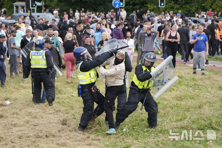 [로더햄=AP/뉴시스] 4일(현지시각) 영국 로더햄의 홀리데이 인 익스프레스 호텔 밖에서 시위대가 반(反)이민 시위를 벌이며 경찰과 충돌하고 있다. 이 호텔은 과거 망명 신청자를 수용해서 비판받은 바 있다. 반이민 시위는 지난달 29일 사우스포트에서 어린이 3명을 살해한 흉기 난동 사건의 용의자가 이슬람교도 난민 신청자라는 허위 사실이 확산하면서 영국 전역에서 격화하고 있다. 2024.08.05.