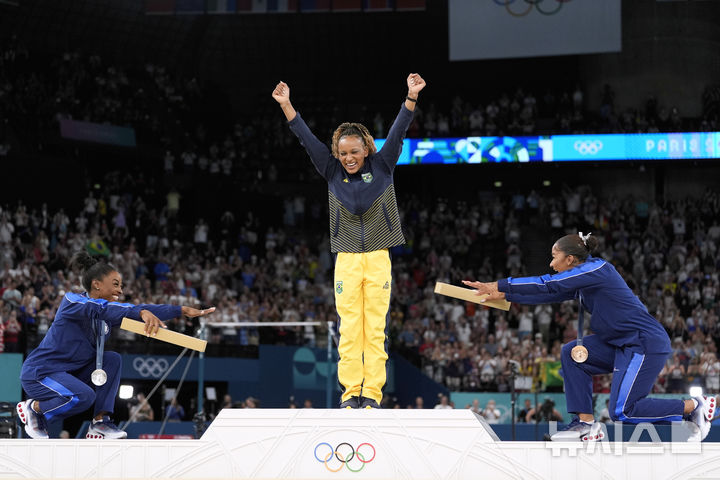 [파리=AP/뉴시스] '2024 파리올림픽' 기계체조 여자 마루운동 은메달리스트 시몬 바일스(왼쪽)와 동메달리스트 조던 차일스(오른쪽)이 5일(한국시각) 프랑스 파리의 베르시 아레나에서 열린 대회 기계체조 여자 마루운동 시상식에서 금메달리스트 레베카 안드라데를 위해 세리머니를 펼치고 있다. 2024.08.05.